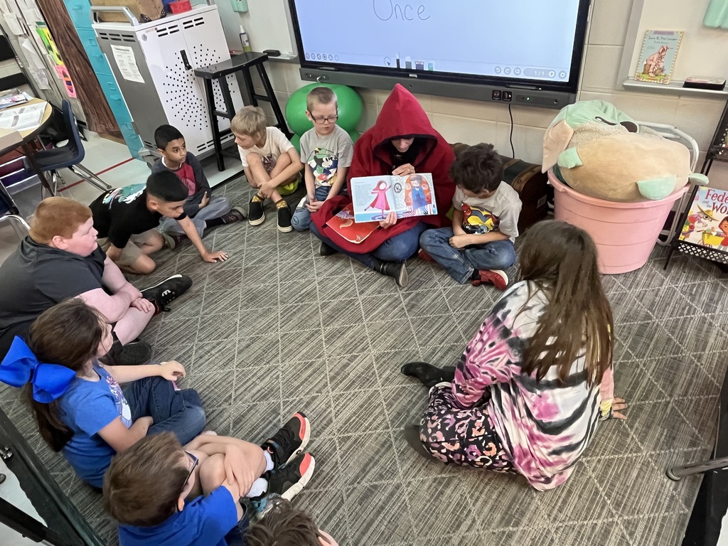teacher reading a book to students