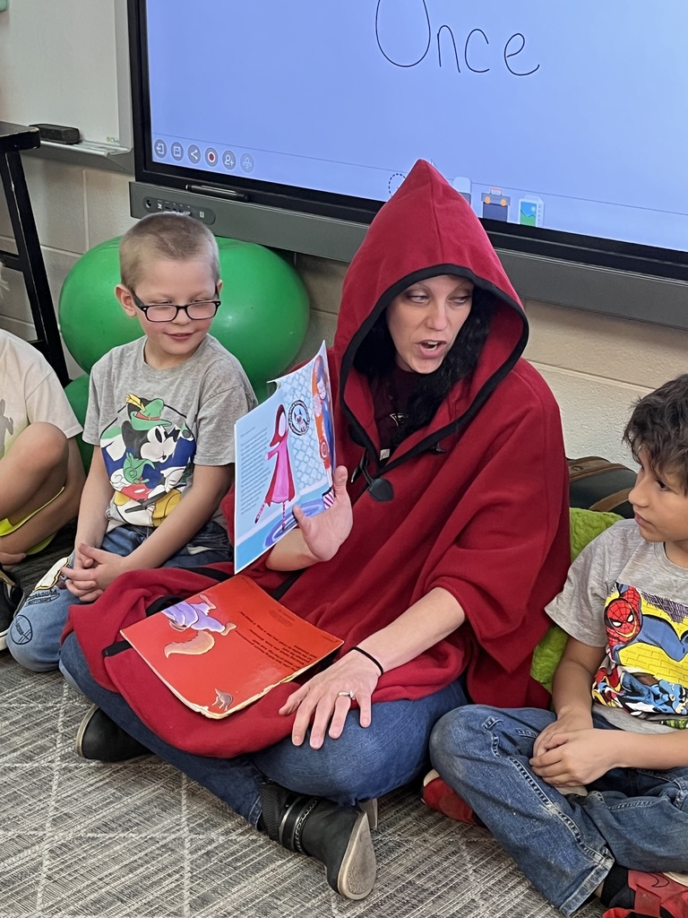 teacher reading a book to students